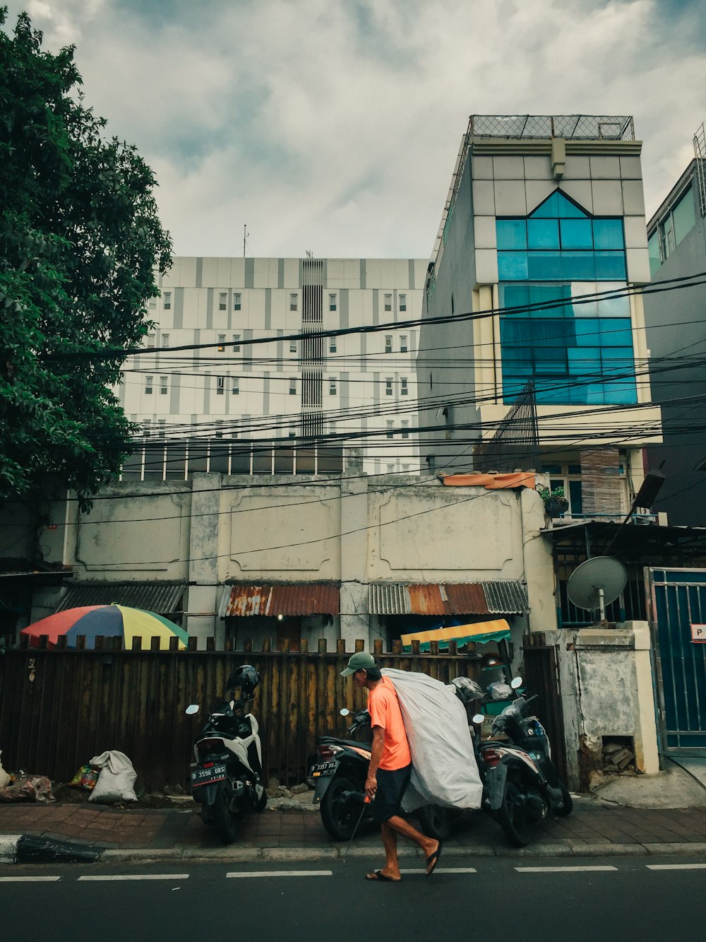 man carrying white sack walking on street