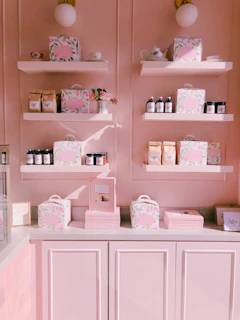 Shelves displaying an array of unique handmade gifts and DIY kits in soft gold and dusty rose packaging