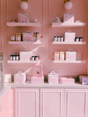 A cozy boutique-style workspace with soft pink and beige tones, featuring elegant personalized gift items arranged delicately.