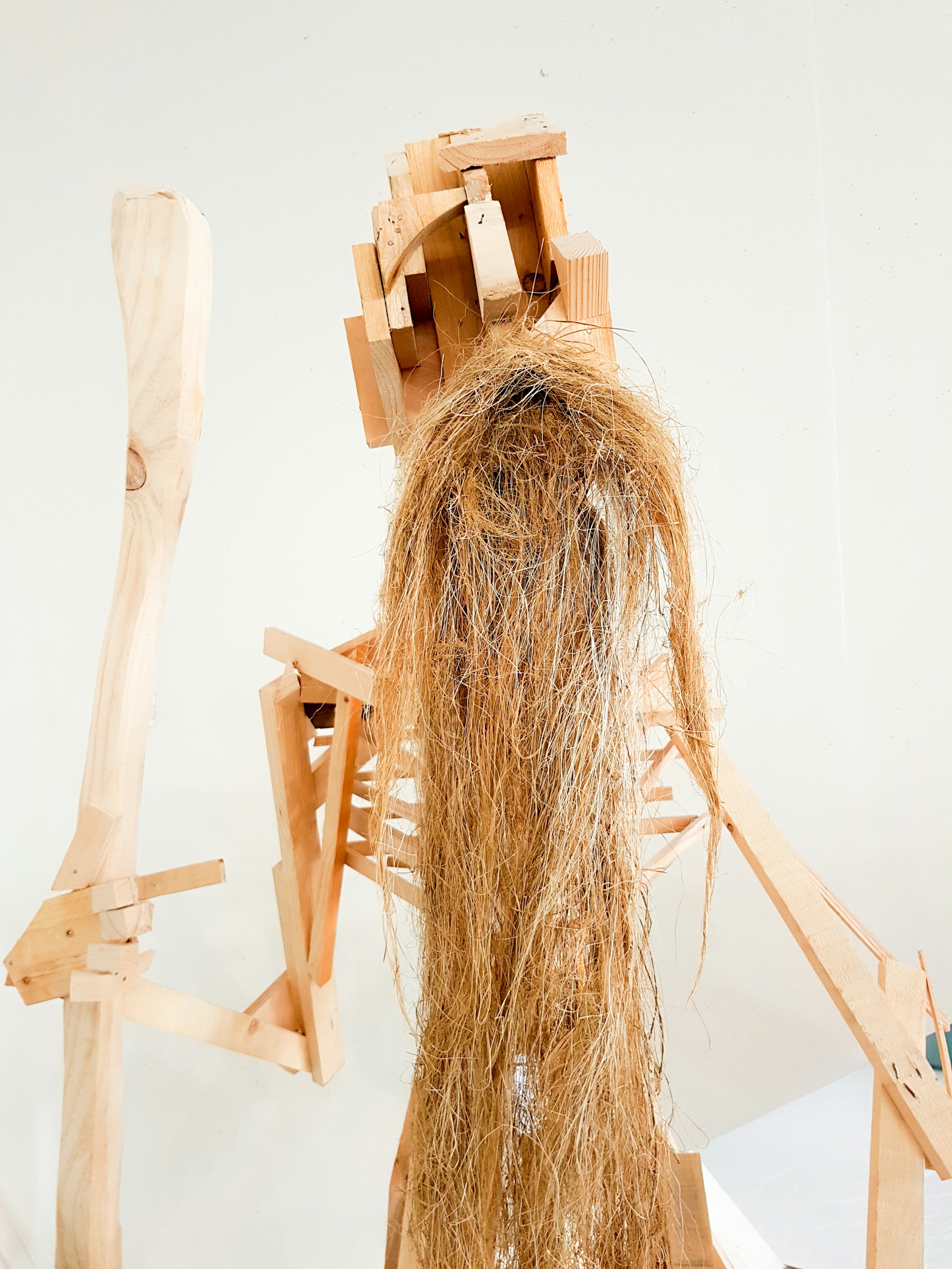 A mixed-media sculpture combining rough wood and smooth metal, capturing a striking contrast of form and texture in a contemporary style.