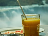 A refreshing glass of freshly squeezed orange juice beside a steaming breakfast platter.
