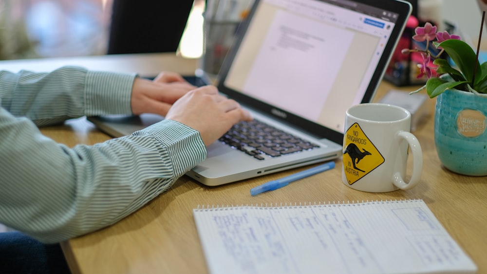 person sitting by the table using laptop