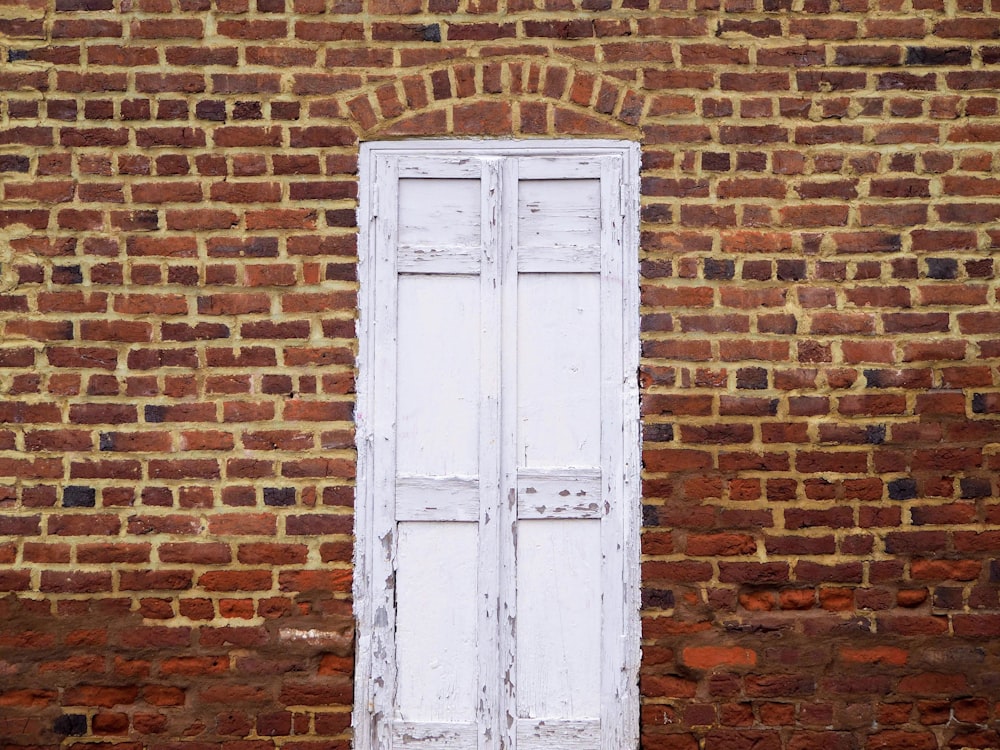 white wooden door beside brown wall
