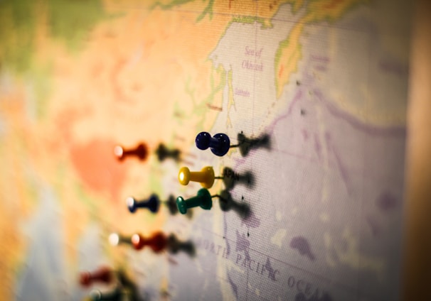 selective focus photography of push pin in map