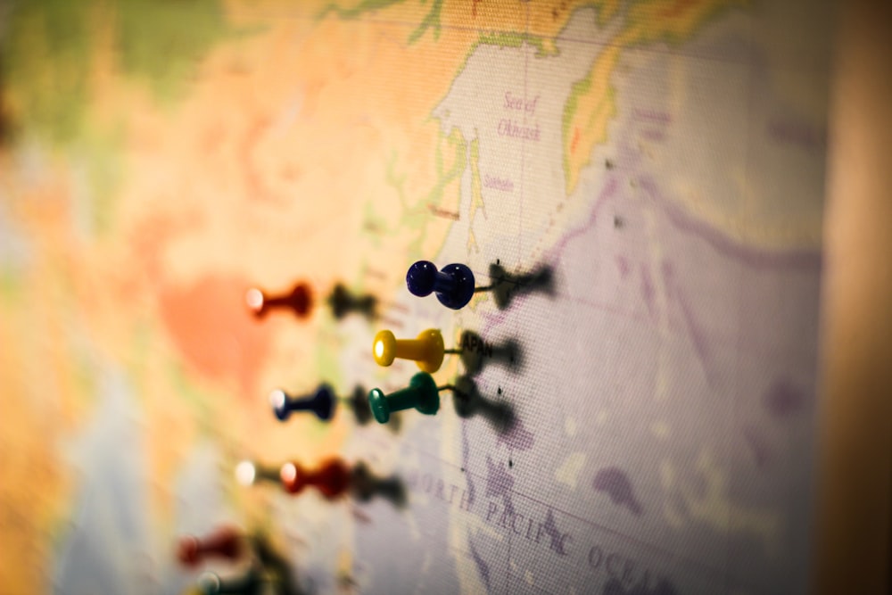 selective focus photography of push pin in map