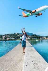 woman in white T-shirt standing near body of water during daytime