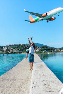 woman in white T-shirt standing near body of water during daytime