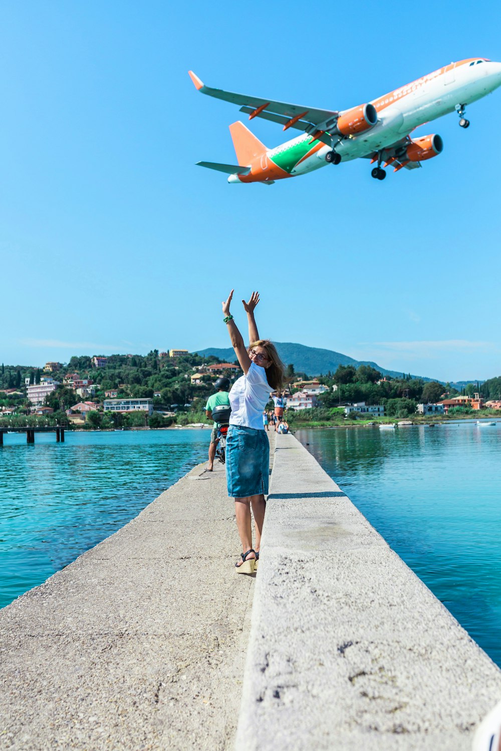 woman in white T-shirt standing near body of water during daytime