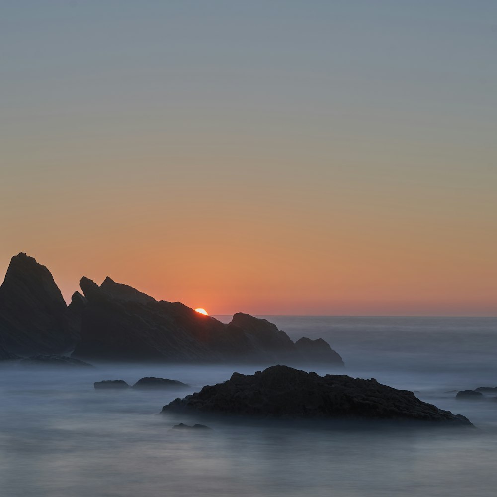 silhouette rock formation during sunset