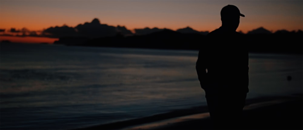 silhouette photo person beside seashore