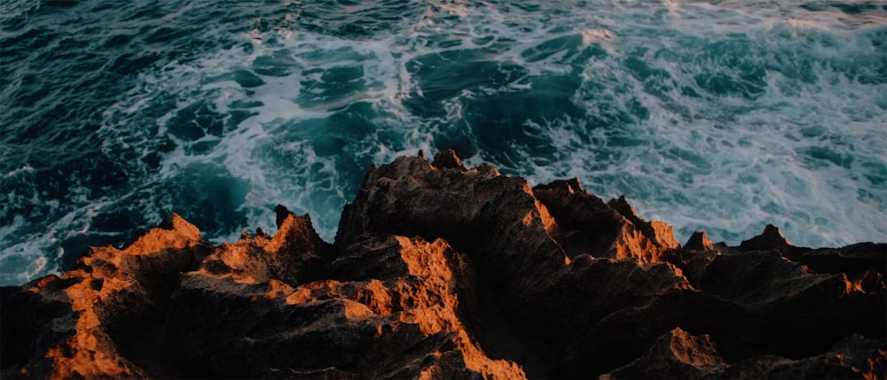 brown rock formation near body of water