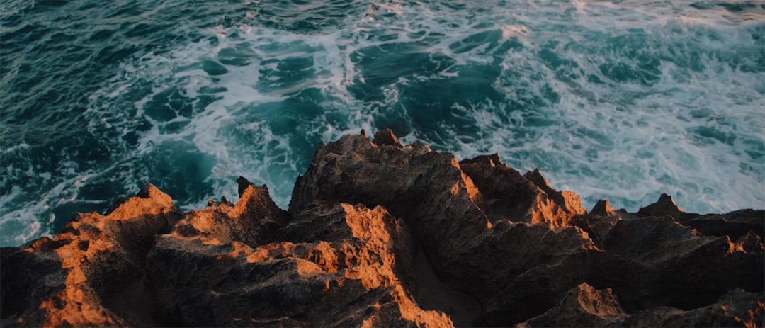 brown rock formation near body of water