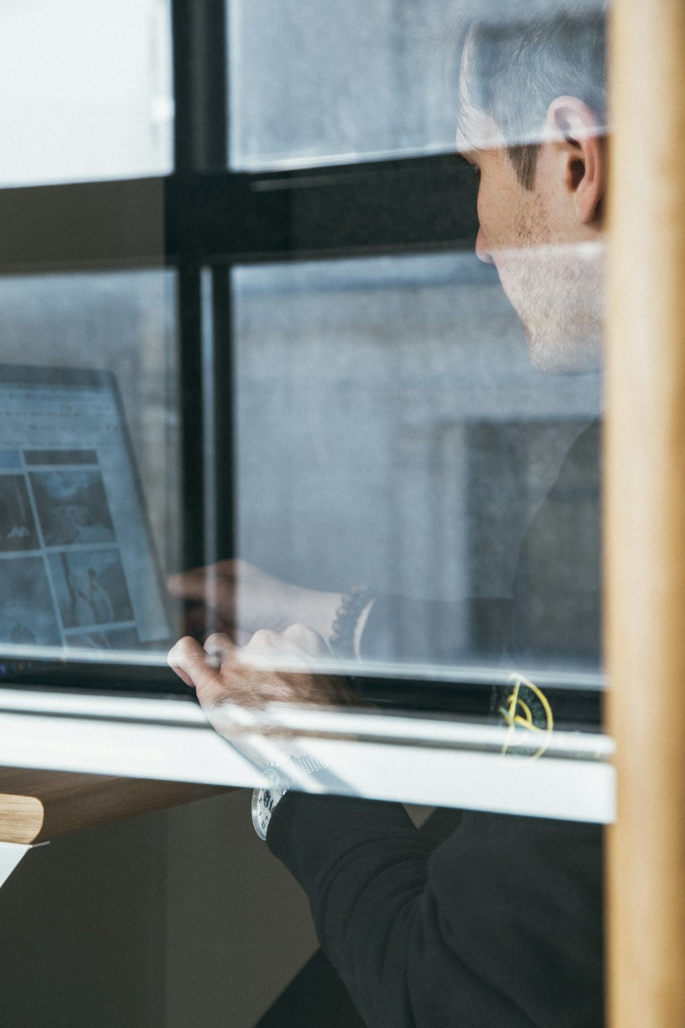 a man sitting at a desk looking at a computer screen