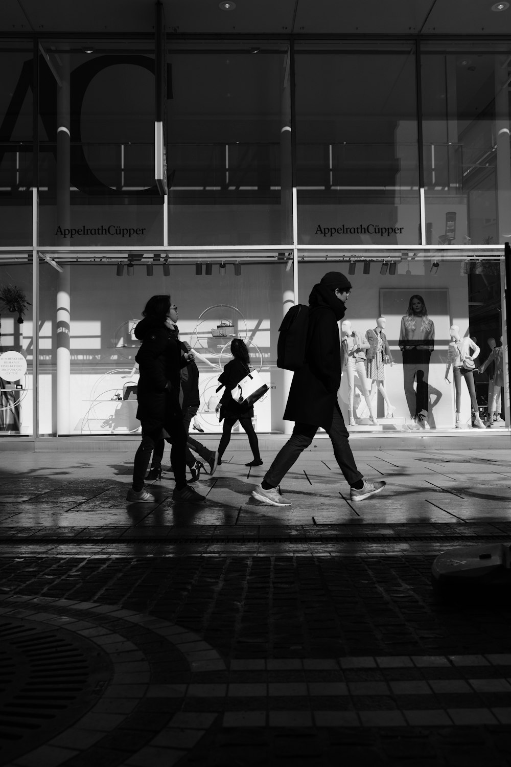 people walking down the street near glass window building