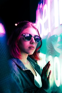 unknown celebrity standing beside blue and purple neon signage