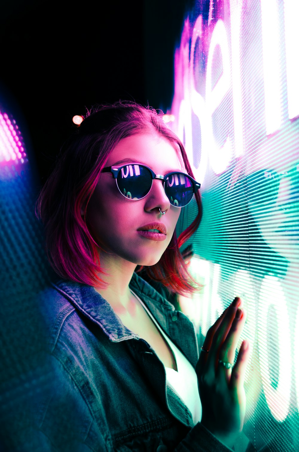 unknown celebrity standing beside blue and purple neon signage