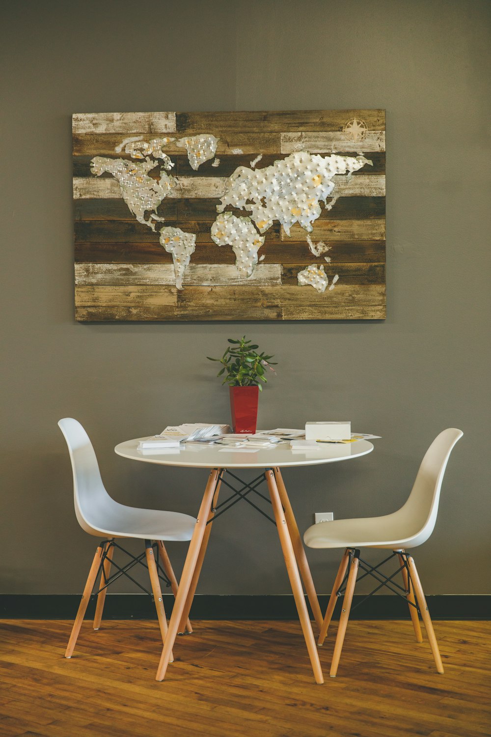 Mesa de madera blanca con dos sillas al lado de la pared