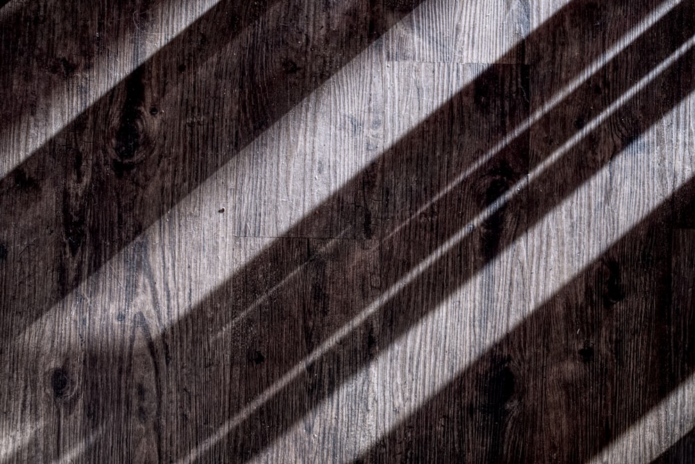the shadow of the blinds on a wooden wall