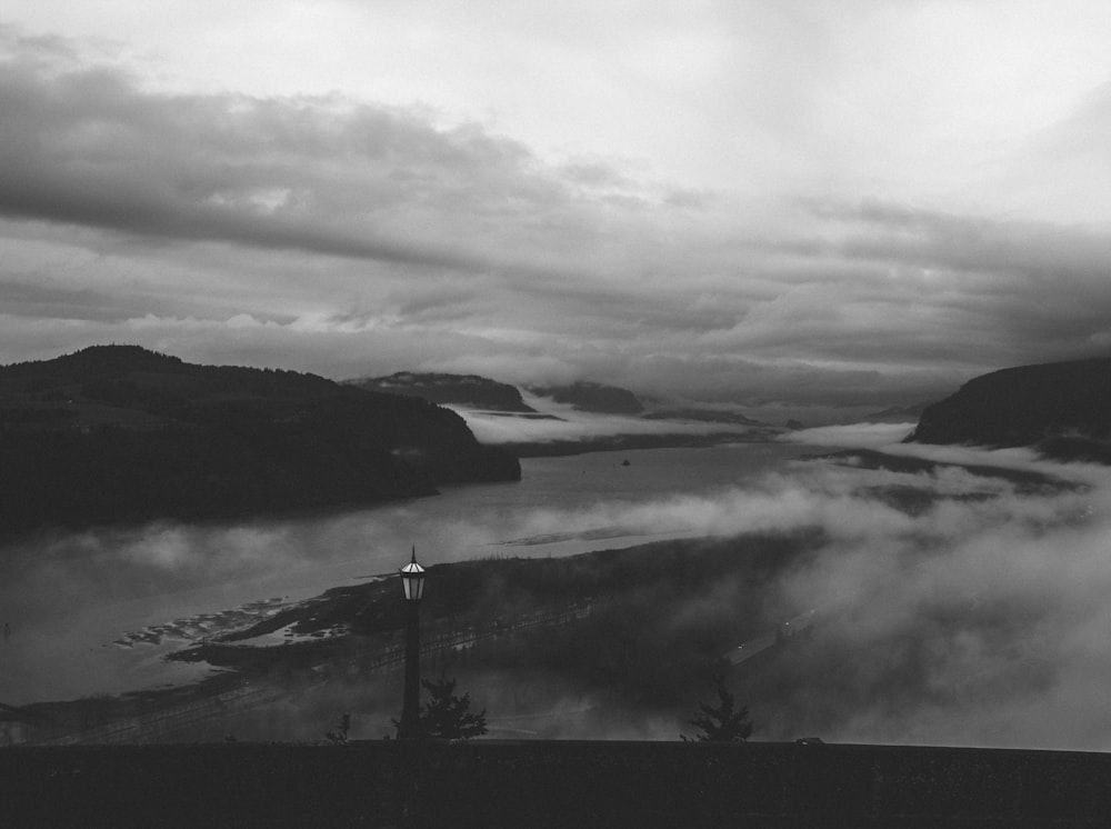 grayscale photo of mountains and fogs