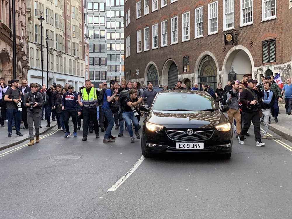 media reporters chasing black vehicle on road