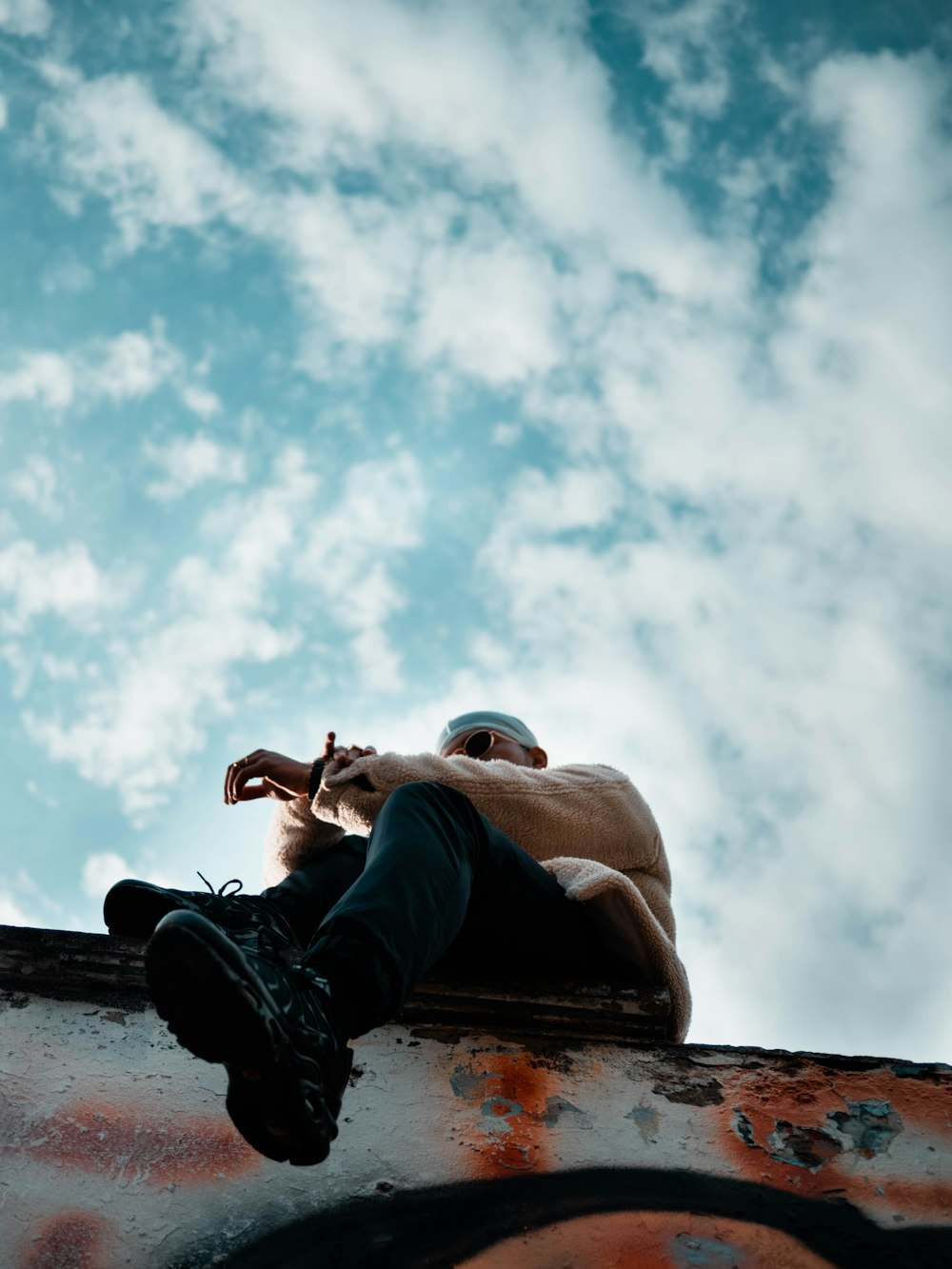 worm's eye view of man sitting on pavement