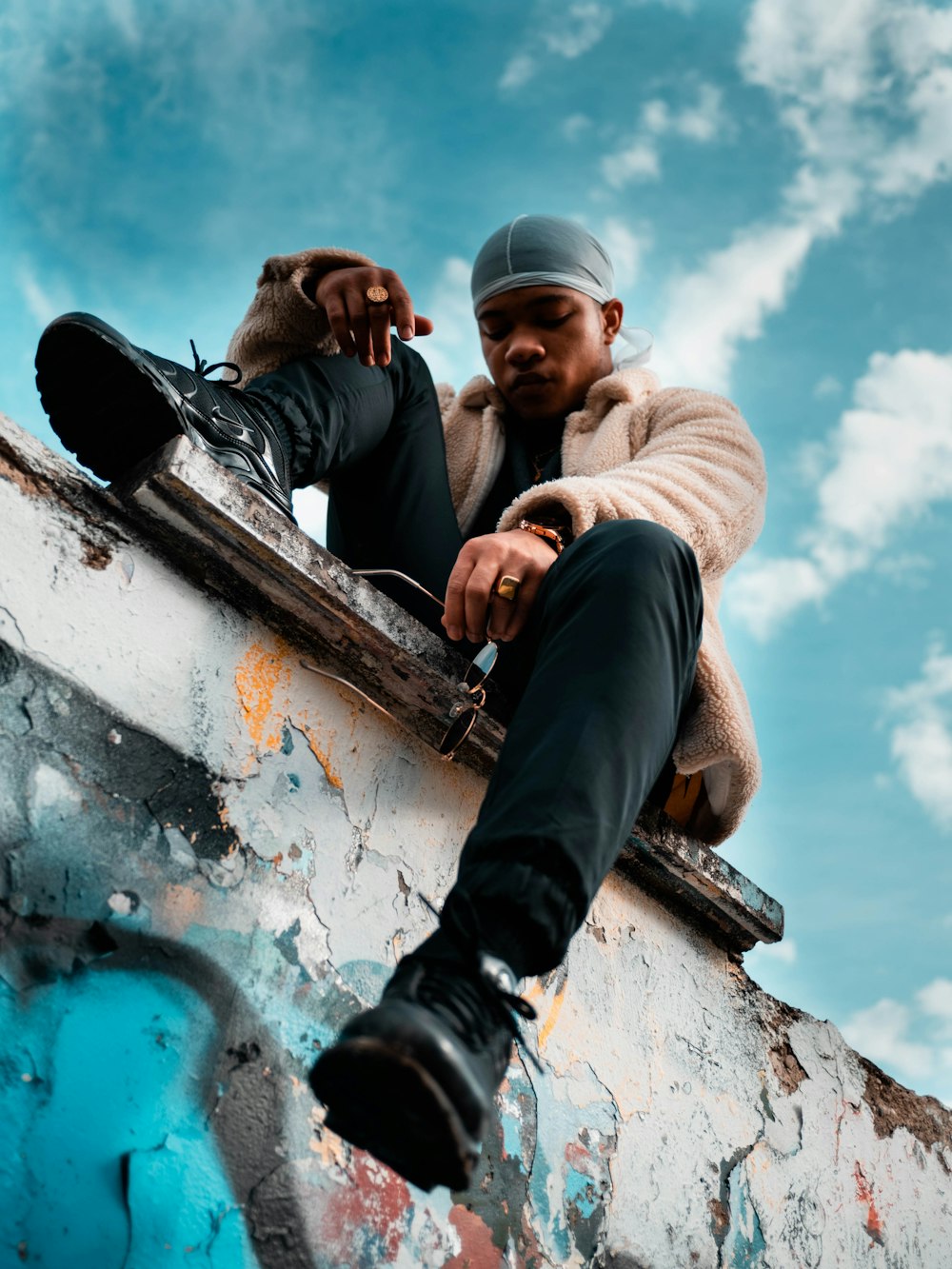 man sitting on pavement under white skies