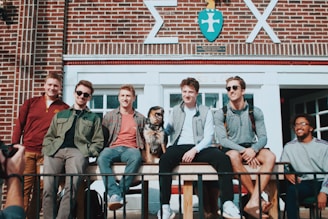 people sitting in front of building while smiling