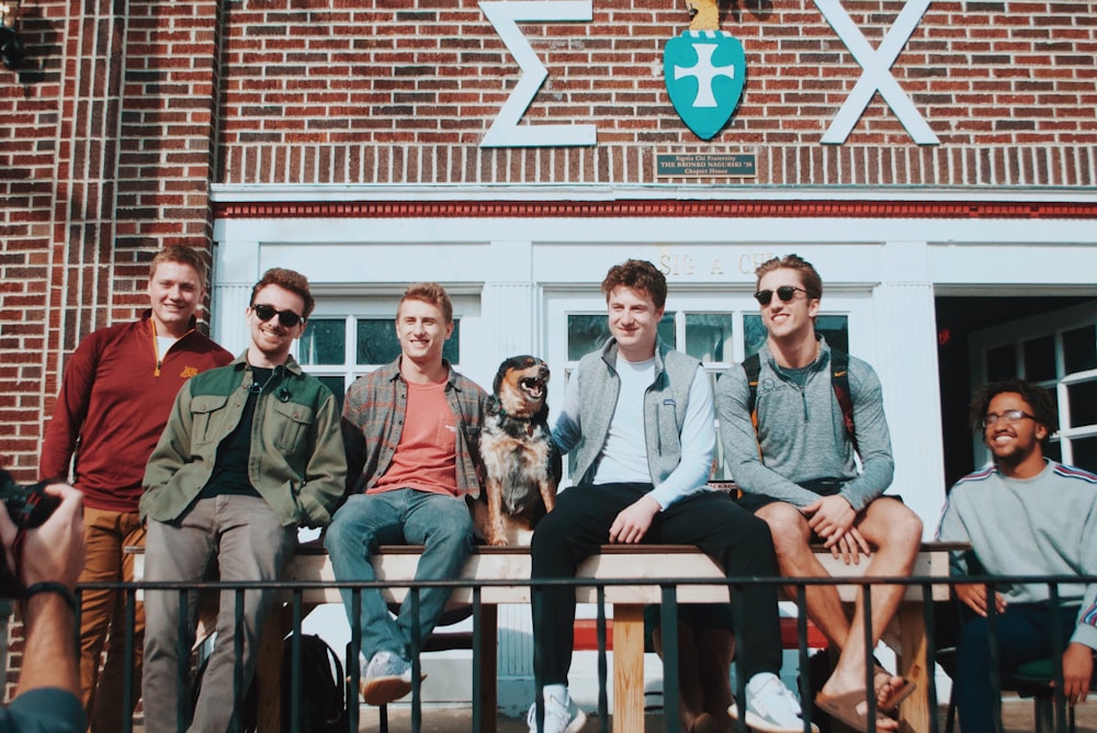 people sitting in front of building while smiling