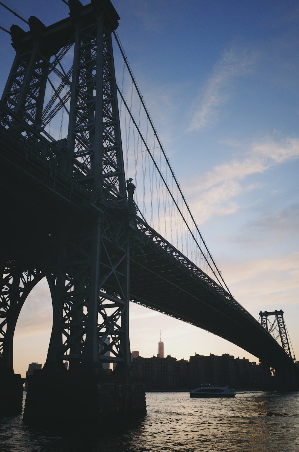 ferry passing under suspension bridge