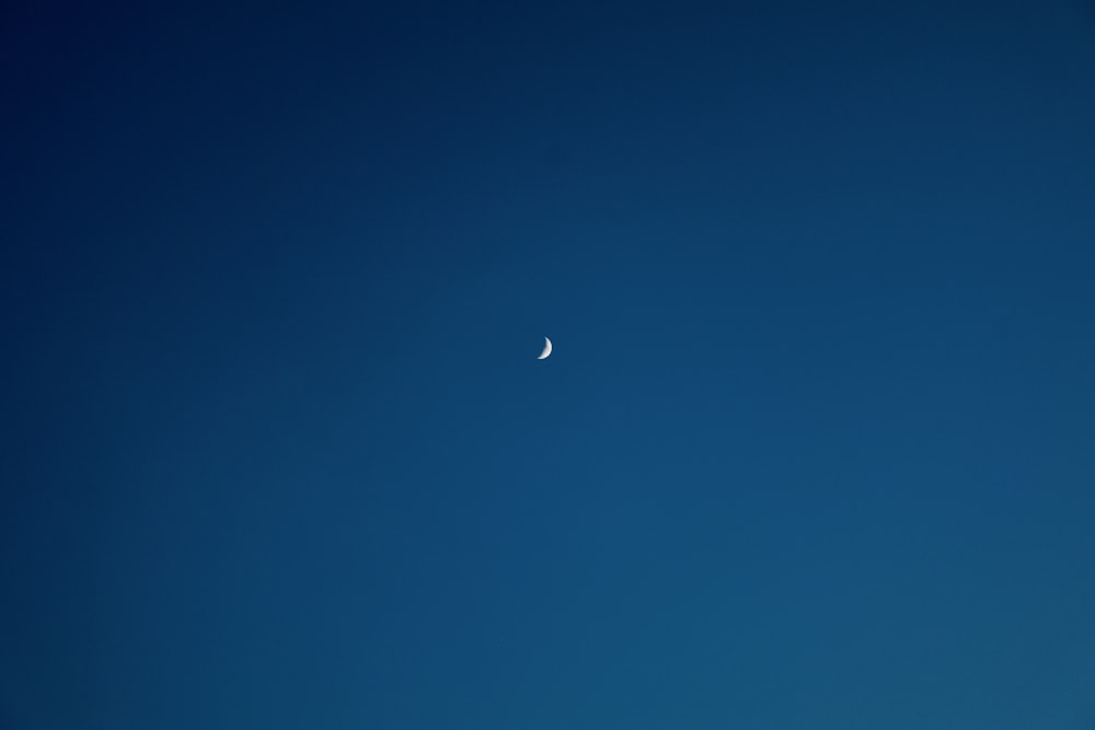 Una media luna se ve en el cielo azul