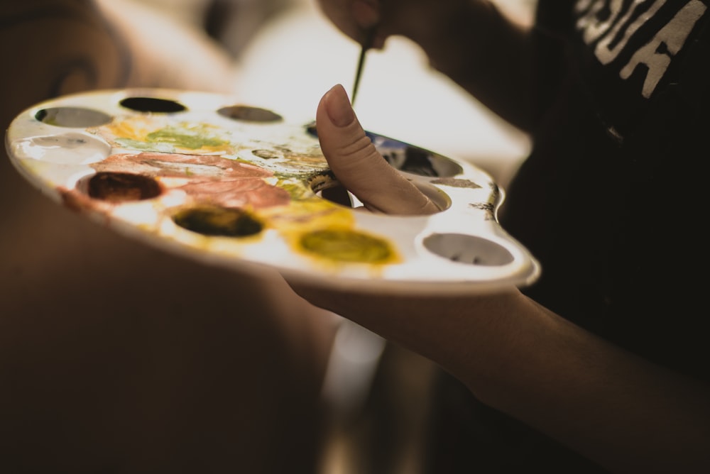 selective focus photography of person holding paint tray