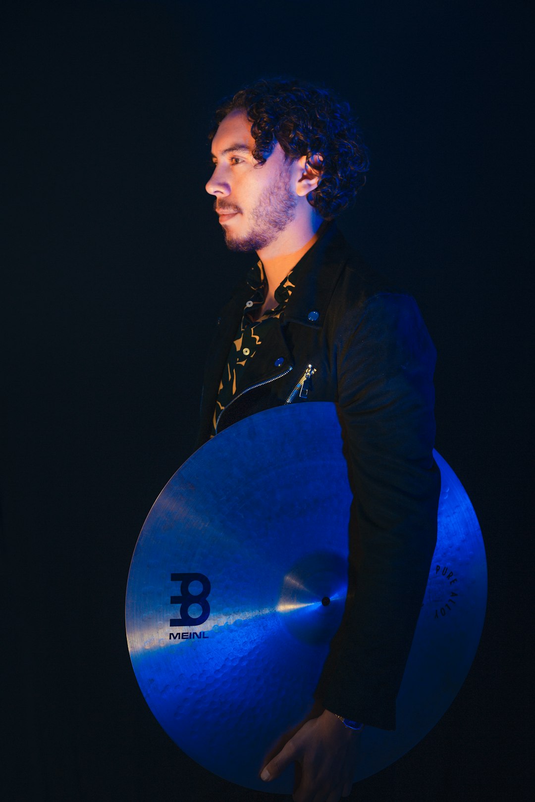 low-light photo of man holding cymbal