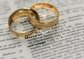 two gold wedding rings on paper