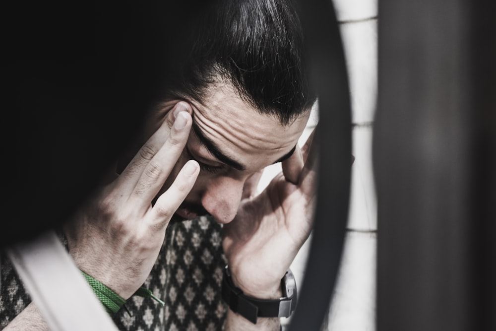 man holding his temples and looking down