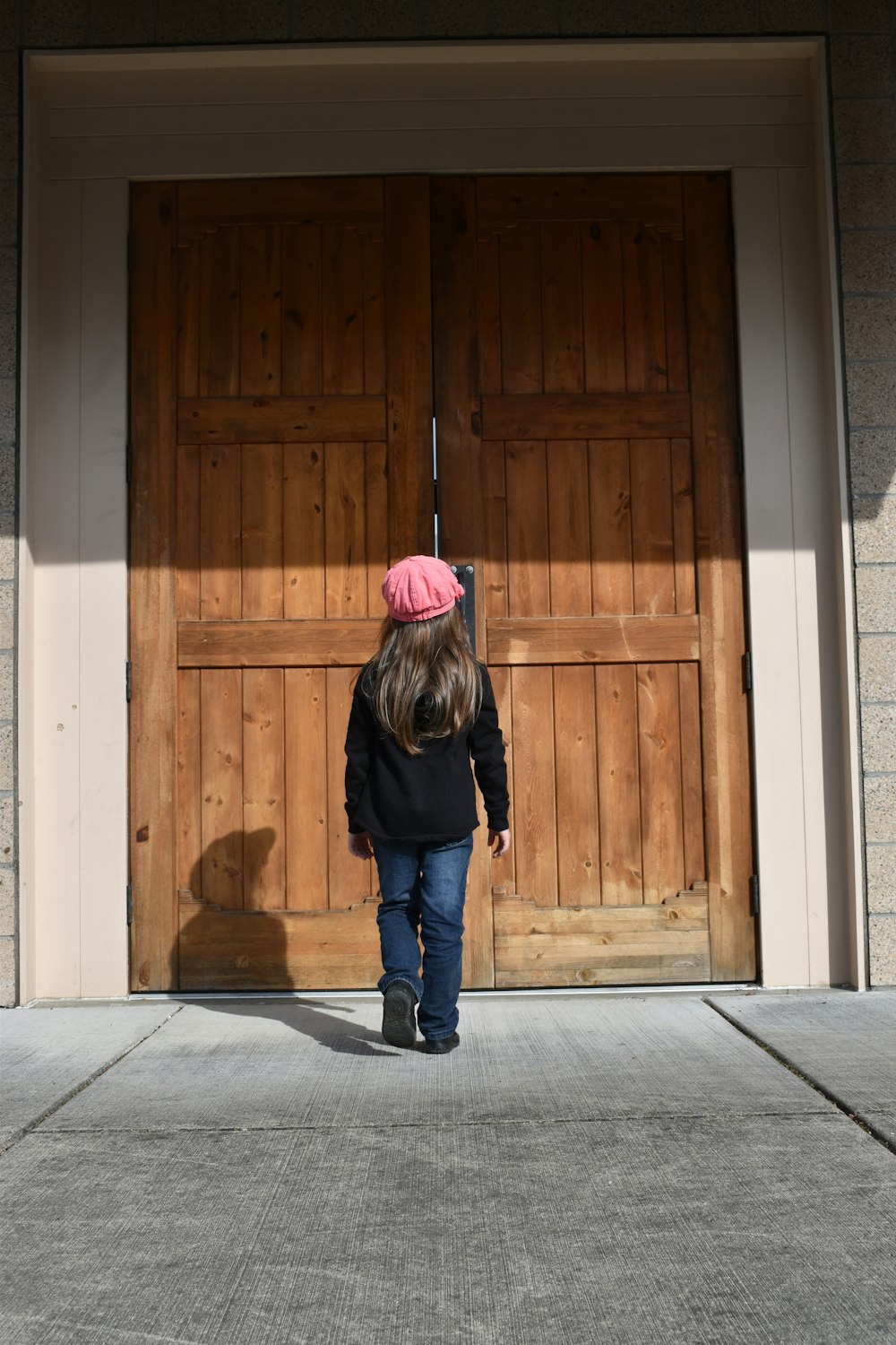 girl standing in front of semi-opened door