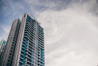A sleek high-rise apartment building with large windows overlooking a bustling cityscape.
