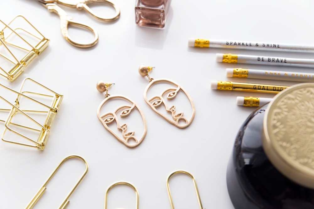 gold-colored face-cutout earrings