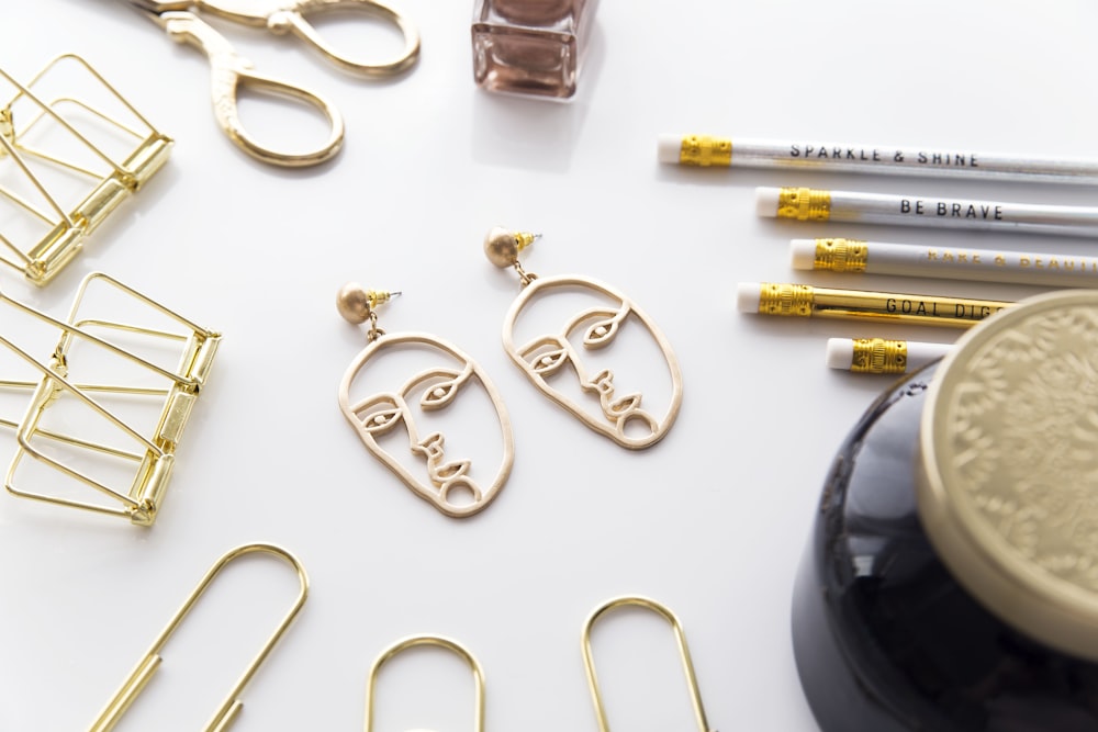 gold-colored face-cutout earrings