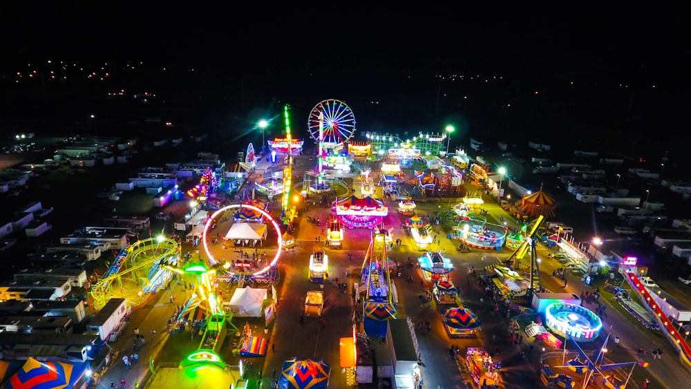 colored neon lights lighting up amusement park rides