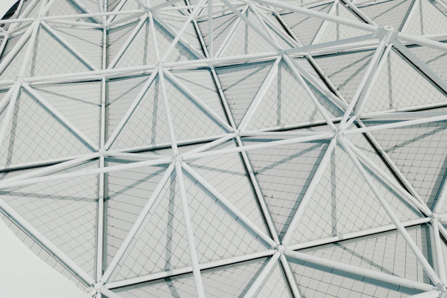 A fine white mesh of connected lines spreading over a pale background