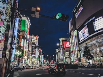 A vibrant city street at night, glowing with neon signs and bustling with life.