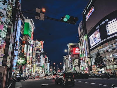 A vibrant night shot of Queen Street West glowing with neon signs and bustling city life.
