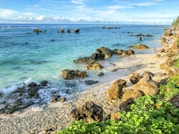 sea water and rocks by the beach coast during daylight