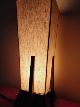 Close-up of a sleek wooden lamp base with smooth grain patterns and a fabric lampshade.