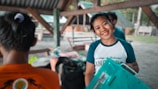 A smiling employee holding a recycled plastic product proudly in the factory