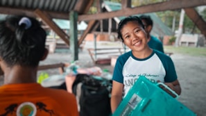 A smiling employee holding a recycled plastic product proudly in the factory