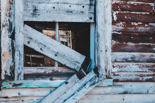 Boarded-up window with a neat, secure wooden frame after damage.