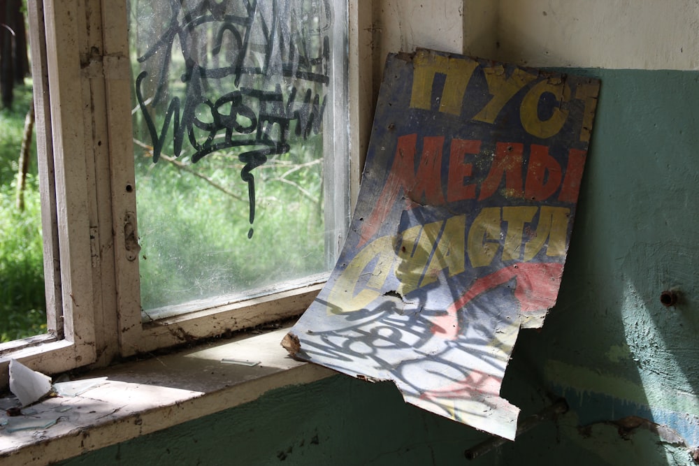 multicolored poster beside wooden framed window