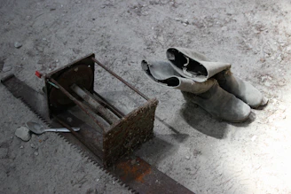 Worker's boots covered in dust next to heavy tools.