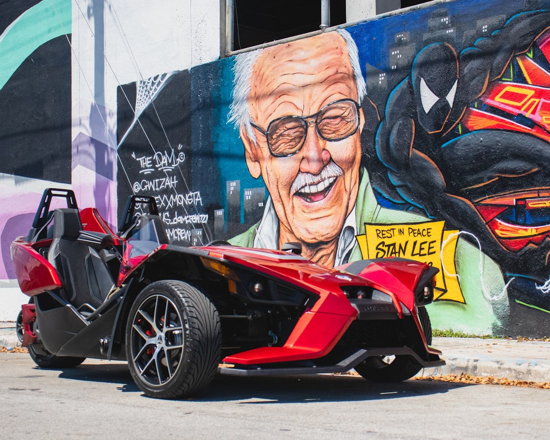 red and black sports car beside wall